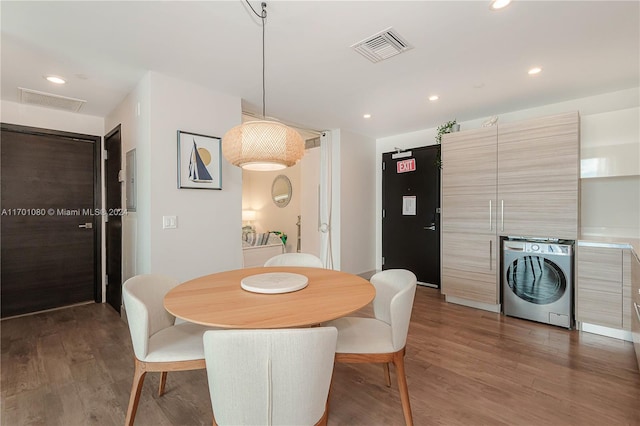 dining area with washer / dryer and dark wood-type flooring