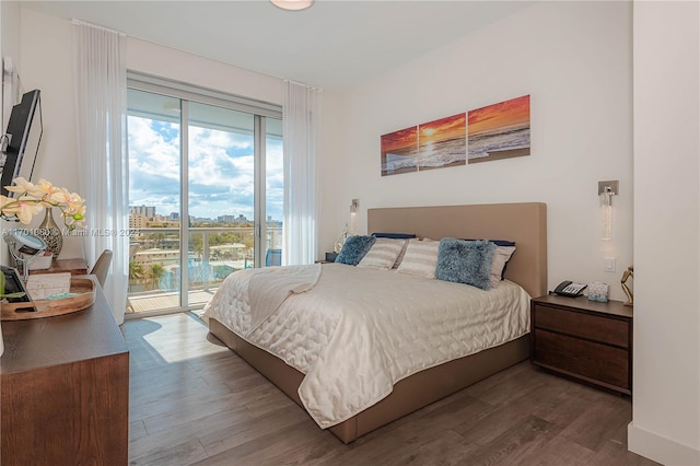 bedroom with hardwood / wood-style floors and access to outside