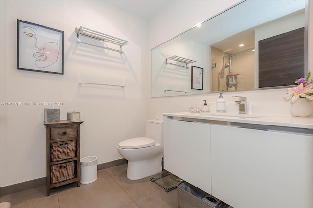 bathroom featuring tile patterned floors, vanity, a shower with shower door, and toilet