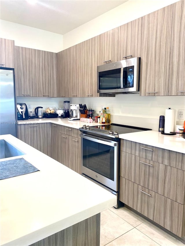 kitchen featuring appliances with stainless steel finishes and light tile patterned floors