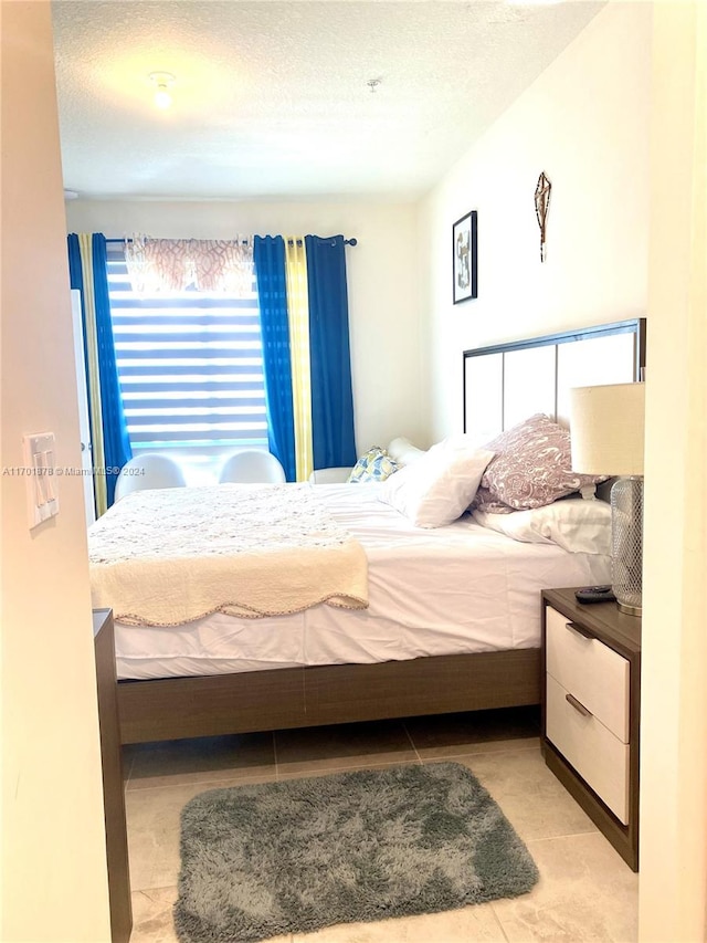 tiled bedroom featuring a textured ceiling