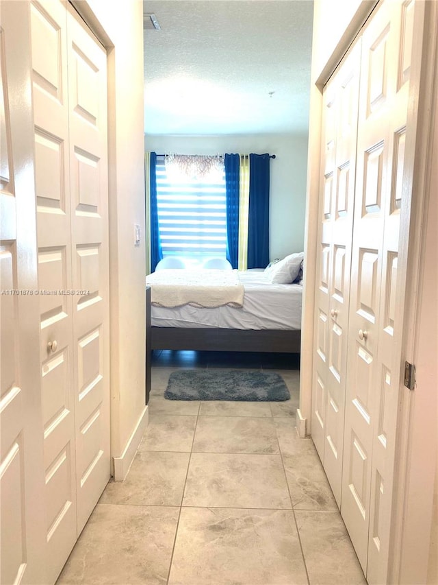 bedroom featuring light tile patterned floors and a textured ceiling