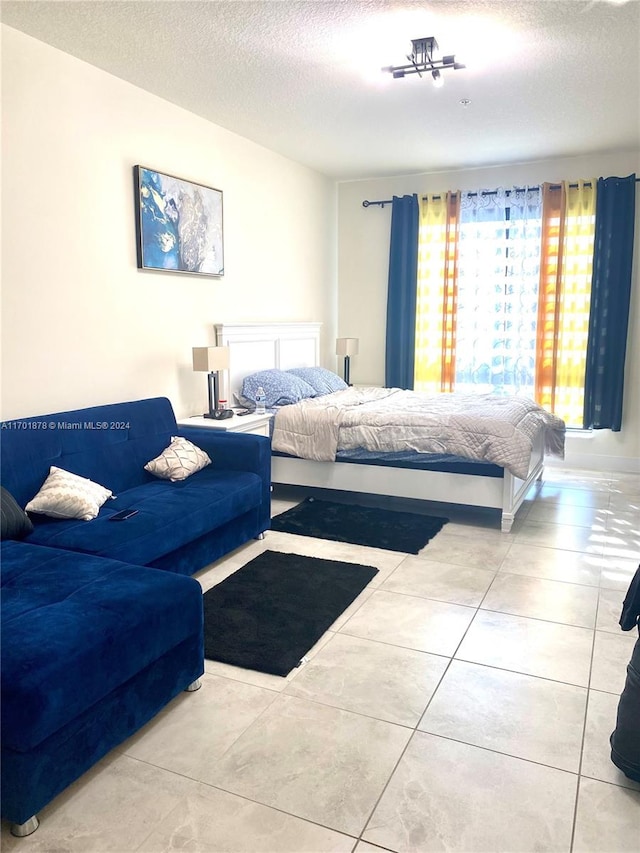 bedroom with light tile patterned floors and a textured ceiling