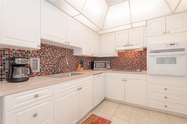 kitchen featuring white cabinetry, sink, light tile patterned flooring, and white appliances