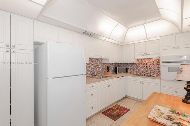 kitchen featuring white appliances, white cabinetry, and sink