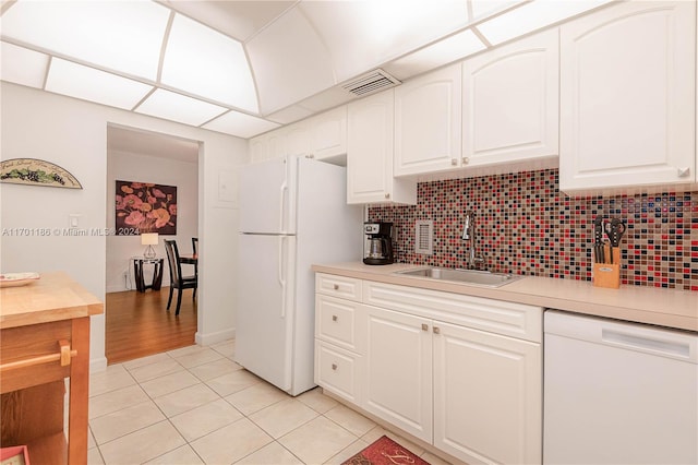 kitchen with sink, white cabinets, white appliances, and light tile patterned floors