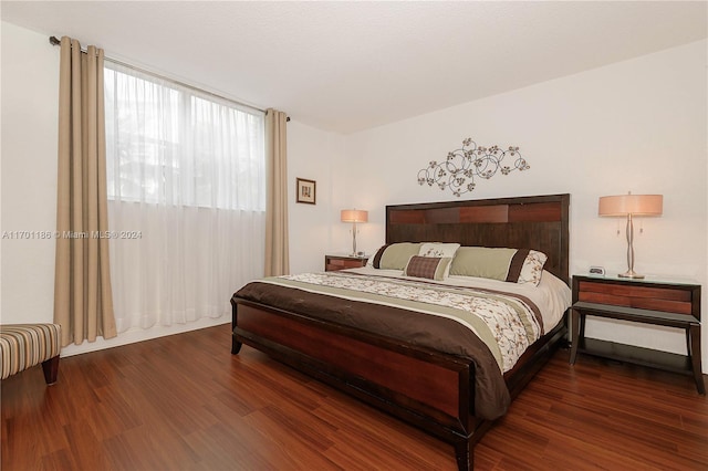 bedroom with dark hardwood / wood-style flooring