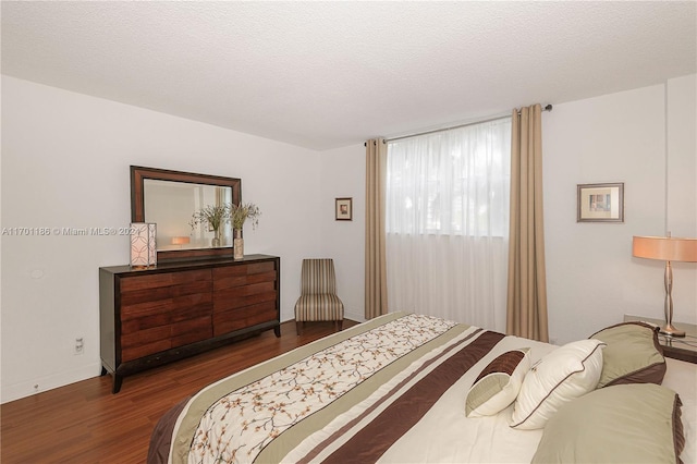 bedroom featuring dark wood-type flooring and a textured ceiling