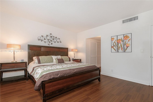 bedroom with a closet and dark wood-type flooring