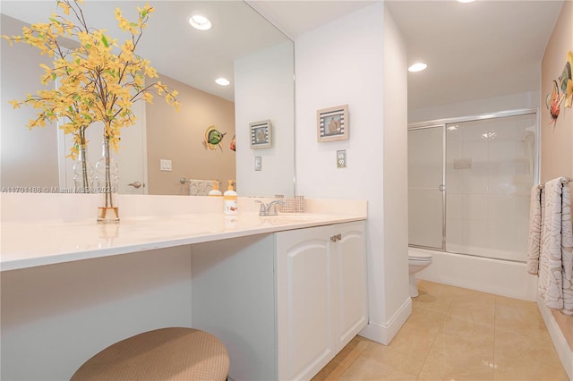 full bathroom with tile patterned flooring, vanity, bath / shower combo with glass door, and toilet