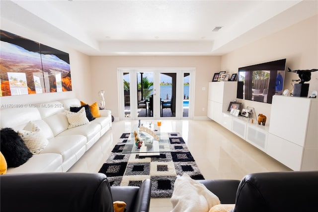 living room featuring french doors and a tray ceiling