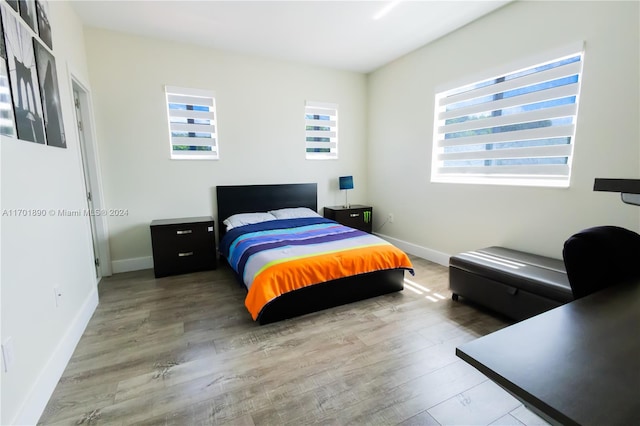 bedroom with multiple windows and hardwood / wood-style floors