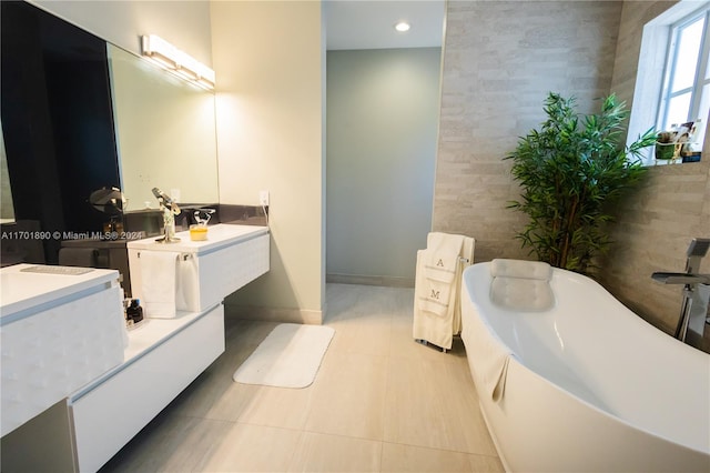 bathroom featuring vanity, tile patterned floors, tile walls, and a tub