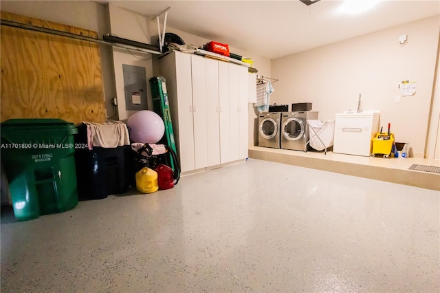 garage featuring independent washer and dryer, refrigerator, and electric panel