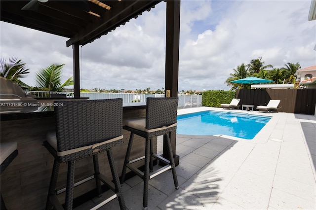 view of pool featuring an outdoor bar and a patio area