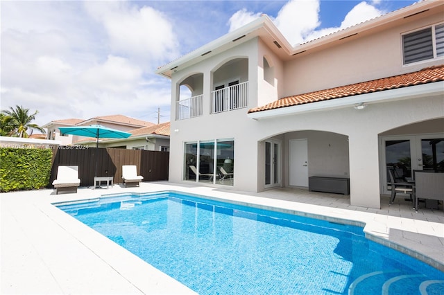 back of house with a fenced in pool and a patio