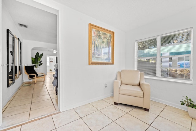 sitting room with light tile patterned floors and ceiling fan