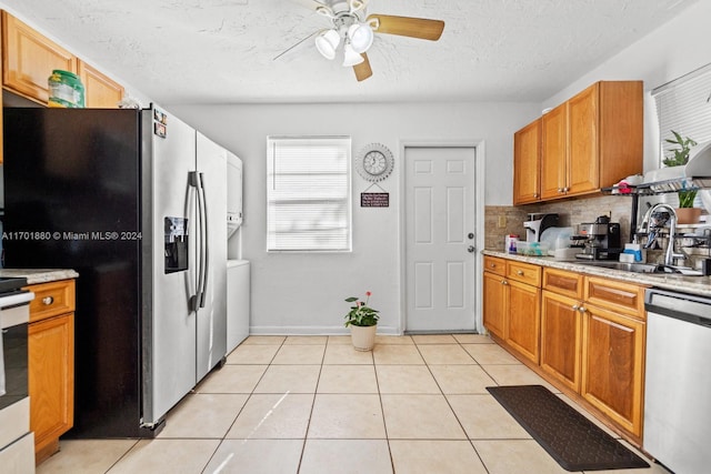 kitchen featuring ceiling fan, sink, light tile patterned flooring, and stainless steel appliances