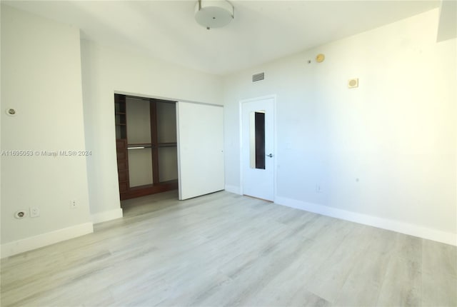 unfurnished bedroom with a closet and light hardwood / wood-style floors