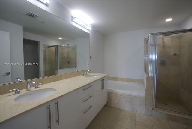 bathroom featuring tile patterned flooring, shower with separate bathtub, and vanity