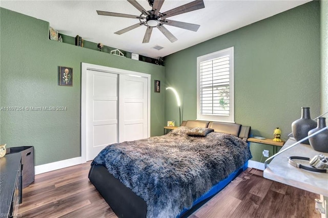 bedroom with ceiling fan, a closet, and dark wood-type flooring