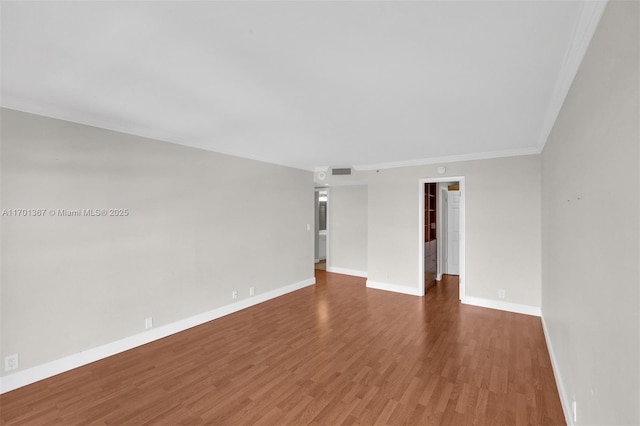 empty room with crown molding and wood-type flooring