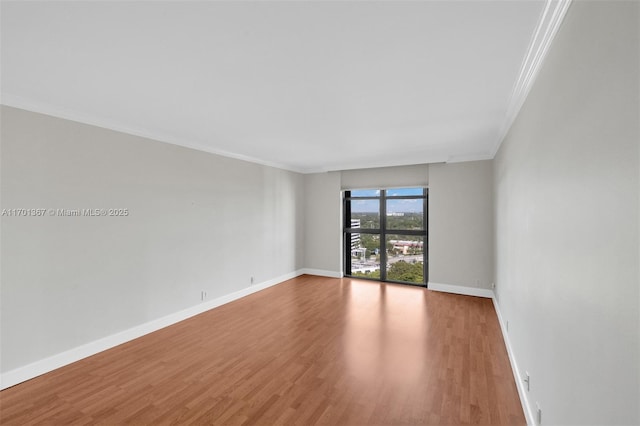 spare room featuring crown molding and light wood-type flooring