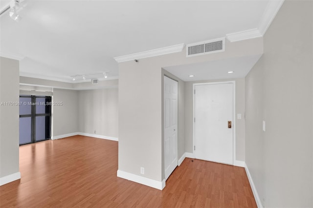 corridor with crown molding, light hardwood / wood-style flooring, and rail lighting