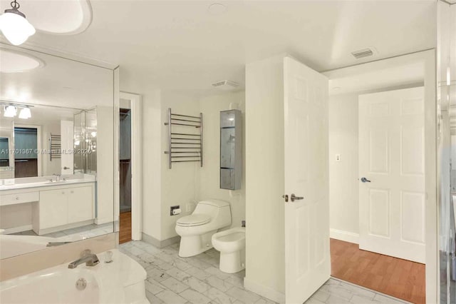 bathroom featuring a bidet, vanity, and toilet