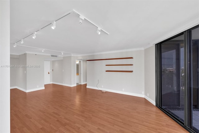 empty room with hardwood / wood-style floors and ornamental molding