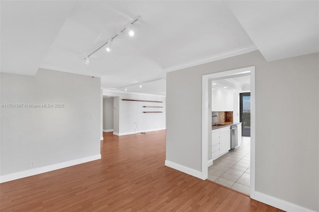 spare room featuring ornamental molding and light hardwood / wood-style flooring