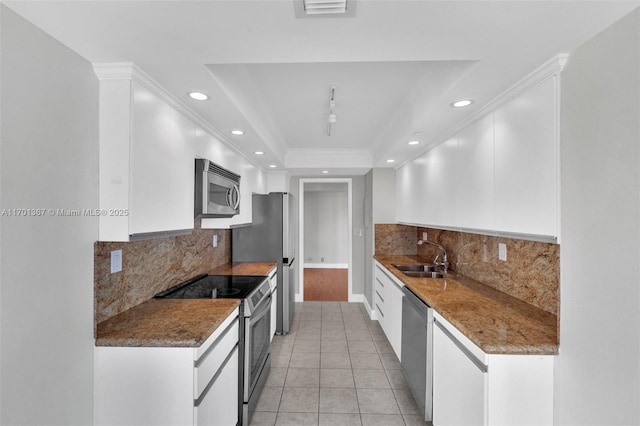 kitchen featuring white cabinetry, sink, stainless steel appliances, and a raised ceiling