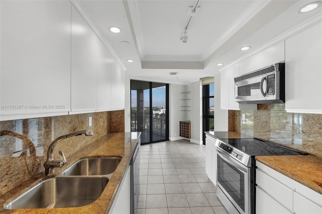 kitchen featuring sink, white cabinetry, crown molding, appliances with stainless steel finishes, and a raised ceiling