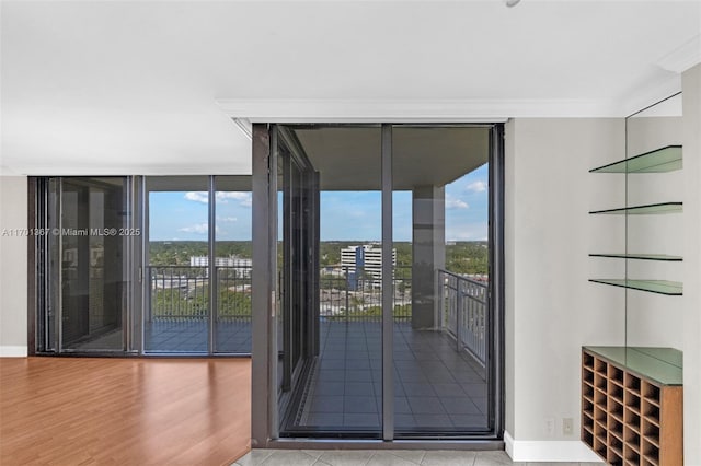 entryway featuring hardwood / wood-style floors, ornamental molding, and expansive windows