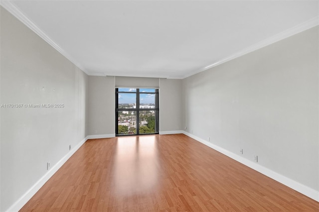 unfurnished room featuring ornamental molding and light hardwood / wood-style floors