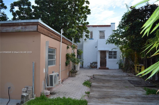 view of side of home with ac unit and a patio