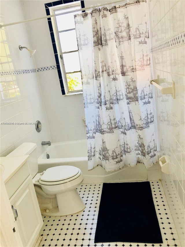 full bathroom with toilet, vanity, tile walls, tile patterned floors, and shower / bath combo