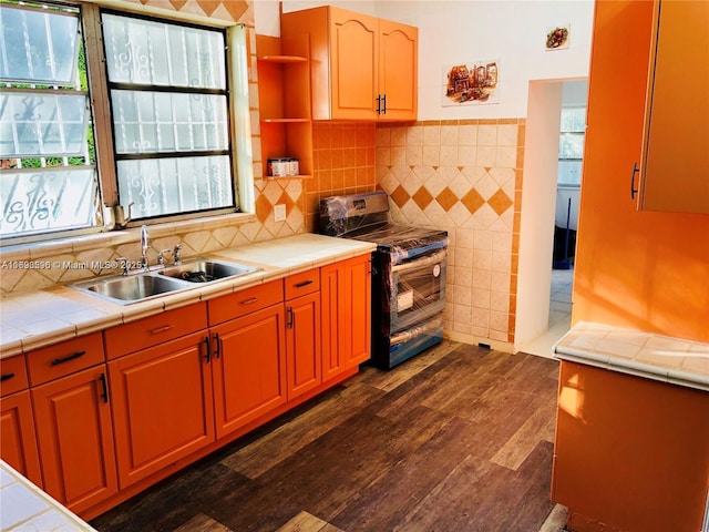 kitchen with tile countertops, black range oven, dark hardwood / wood-style flooring, and sink