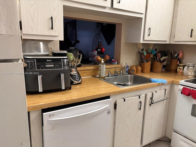 kitchen featuring tasteful backsplash, sink, and white appliances