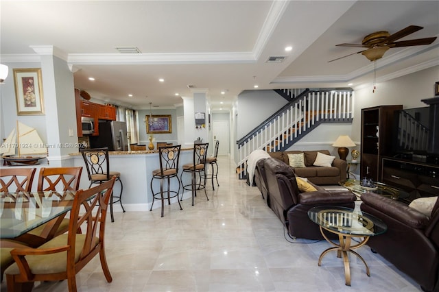 living room with ceiling fan and ornamental molding