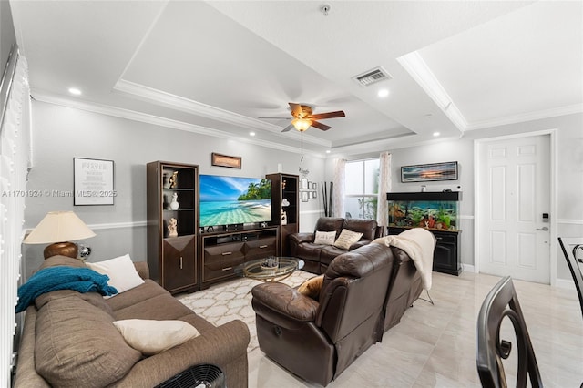 living room with a tray ceiling, ornamental molding, and ceiling fan