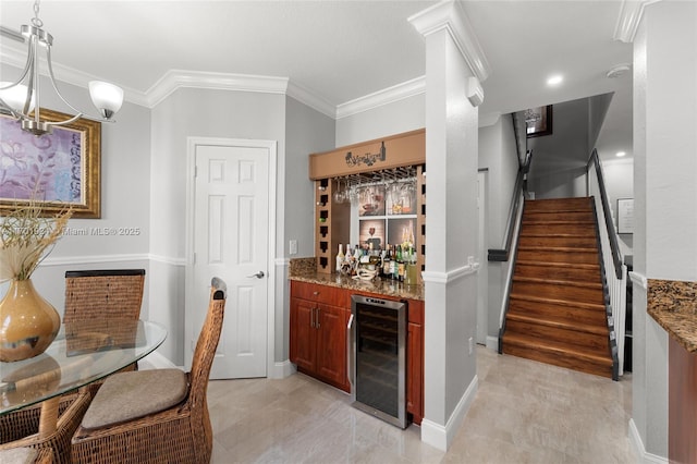 bar with stone counters, ornamental molding, pendant lighting, and beverage cooler