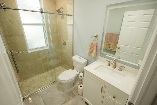 bathroom with vanity, a shower with shower door, and toilet