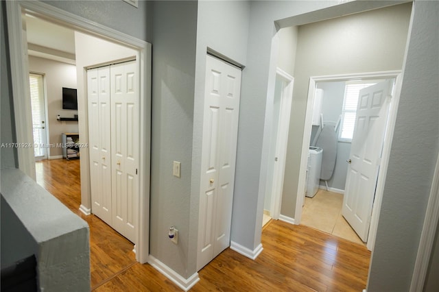 corridor featuring washer / dryer and light hardwood / wood-style floors