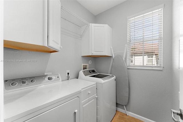 laundry room with cabinets, independent washer and dryer, and light tile patterned floors