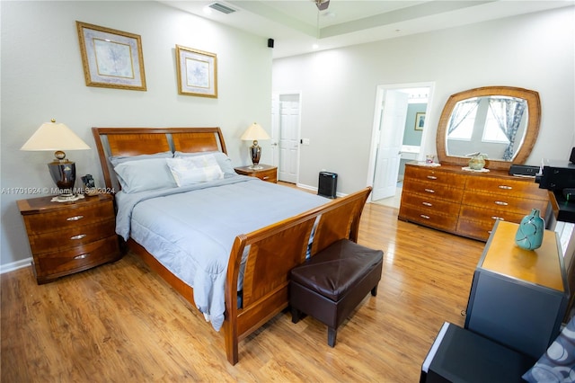 bedroom featuring light wood-type flooring and connected bathroom