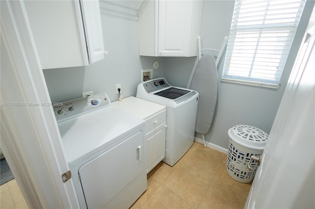 washroom featuring cabinets, light tile patterned flooring, and washer and dryer