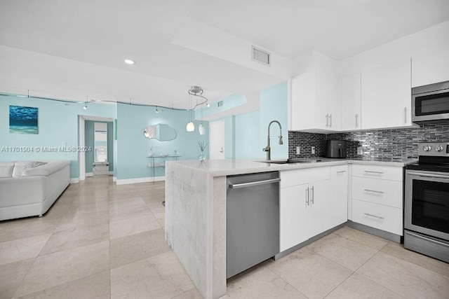 kitchen with white cabinetry, rail lighting, stainless steel appliances, kitchen peninsula, and pendant lighting