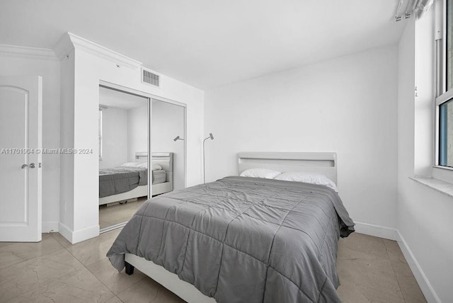 bedroom featuring crown molding and a closet