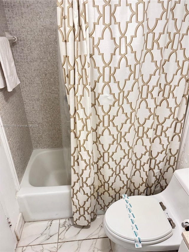 bathroom with toilet and shower / tub combo with curtain